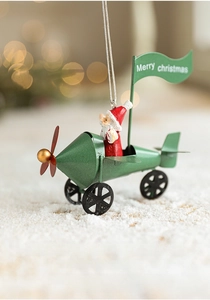 Close-up of a vintage green metal plane ornament with Santa Claus and Merry Christmas flag