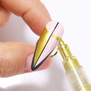 Macro shot of a gold nail art pen creating 3D patterns on pink and black nails