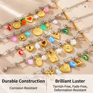 Close-up of bohemian steel bracelets with colorful heart and flower charms on sand surface