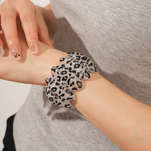 Close-up of black and white leopard print resin bangle on a model's wrist