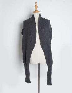 Detail view of dark grey knitted scarf with sleeves on a mannequin against white background