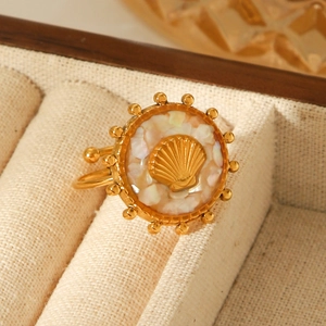 Macro shot of gold-plated seashell ring with white shell inlay in a beige jewelry box