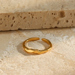 Detailed view of a gold irregular bamboo-textured open ring on a natural stone surface