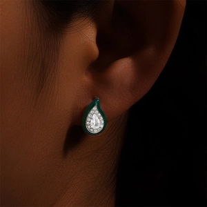 Close-up of S925 silver green enamel drop earring with diamonds on earlobe