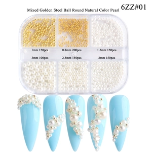 Mixed gold steel beads and white pearls for nail art shown on blue artificial nails
