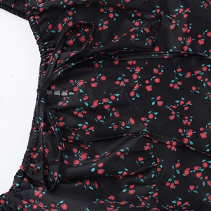 Dettaglio della stampa floreale e del laccio in vita su un abito slim nero da donna