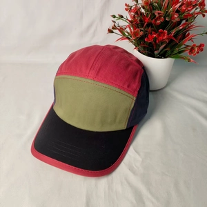 Detailed top view of a 5-panel baseball cap featuring red, green, and black patchwork