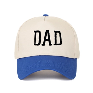 Detailansicht der Retro-DAD-Stickerei auf cremefarbener und königsblauer Trucker-Cap