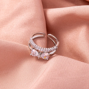 Macro shot of double-layer ring featuring heart zircons and pavé diamonds on pink silk