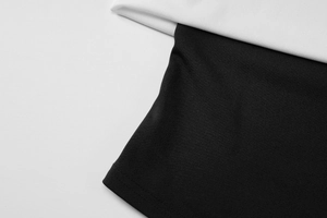 Detail shot showing the contrast of white and black knitted fabric texture on cropped top