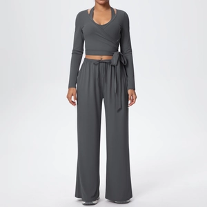 Détails de l'ensemble de yoga gris foncé avec haut cache-cœur à manches longues et pantalon