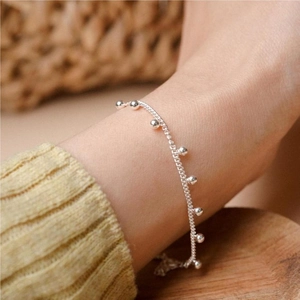 Detailed view of a delicate S925 sterling silver beaded bracelet worn on wrist