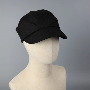 Detail of black cotton linen newsboy hat showing breathable textured fabric and side folds