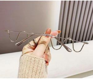 Detail of silver wavy metal eyeglass frame featuring unique geometric rimless design