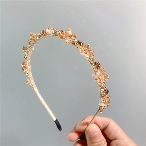 Dettaglio macro del cerchietto dorato di lusso con cristalli ambrati e finitura metallica