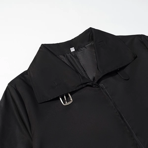 Trench-coat noir moderne avec col à revers élégant et détails de boucles en métal argenté