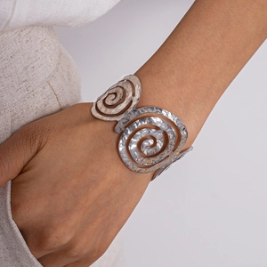 Détail d'un bracelet manchette spirale argentée avec une texture martelée artistique