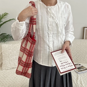 Red and white checkered fleece tote bag paired with a white ruffled shirt and grey skirt
