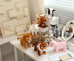 Collection of plush stuffed animals including lion, tiger, and deer on a desk setup