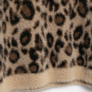 Close-up of vintage leopard print plush sweater featuring soft texture and beige hem