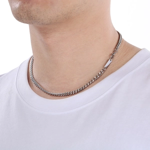 Close-up of a silver stainless steel Cuban link necklace with a square pendant on a model
