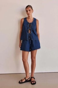 Detail of high-waist dark blue denim two-piece set with sleeveless tie-up top and shorts