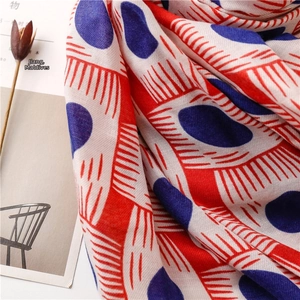 Detail of soft cotton scarf with red and blue abstract geometric dot patterns