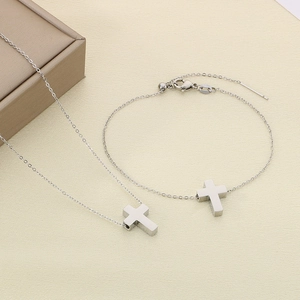 Detail view of silver stainless steel cross pendant necklace and bracelet jewelry set