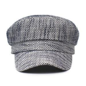 Detail of grey textured tweed newsboy hat featuring woven fabric and a short flat brim