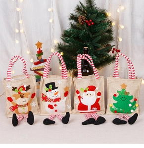 Detailed view of four linen Christmas gift bags featuring reindeer and snowman designs