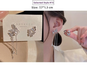 Detail view of silver butterfly tassel earrings with cubic zirconia on model