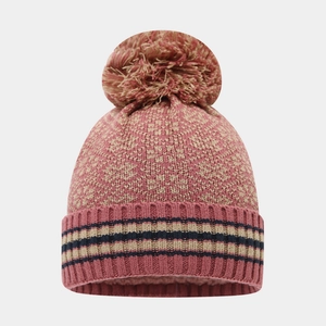 Détail du bonnet en tricot rose avec motif jacquard beige et pompon moelleux en haut