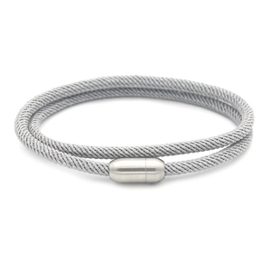 Close-up of grey woven bracelet with a matte silver magnetic cylinder clasp
