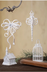Close-up of white glittery Christmas bow and filigree pendant ornaments on a branch