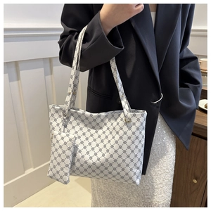 Macro shot of large white tote bag with black chain print and matching mini coin purse