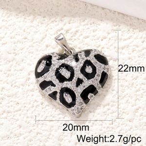 Detailed view of silver heart pendant with leopard enamel pattern and clear gemstone inlay