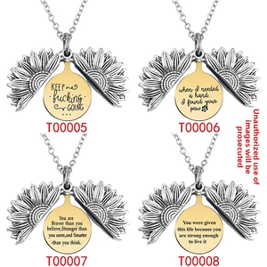 Detail of four sunflower locket necklaces with engraved inspirational messages inside