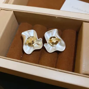 Elegant two-tone flower stud earrings with silver wavy petals and golden faceted center