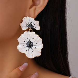 Chic vintage ginkgo flower earrings in white and gold enamel worn by a model
