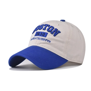 Detailed close-up of blue 3D Boston embroidery on a beige cotton baseball cap