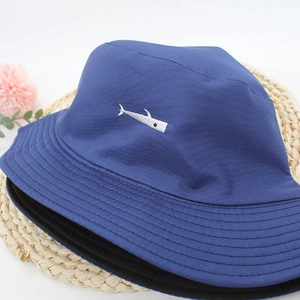 Detailed shot of dark blue canvas bucket hat with high-quality white shark embroidery