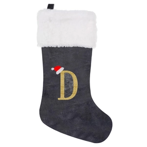 Close-up of a grey velvet Christmas stocking with a golden glitter letter D and mini Santa hat