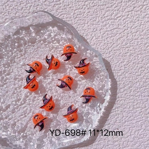 Macro detail of Halloween pumpkin resin charms with witch hats on a glass tray