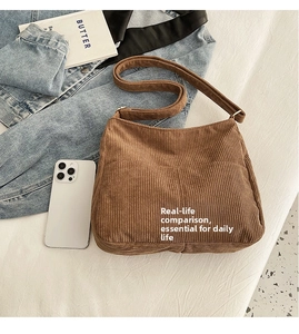 Brown corduroy crossbody bag shown with a smartphone to demonstrate the large capacity