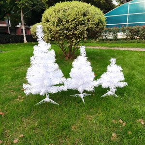 Three different sizes of artificial white Christmas trees with matching white metal stands