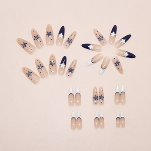 Macro shot of blue star pattern and French polka dot press-on nails in stiletto shape