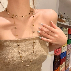 Collier double rang plaqué or 18k avec pierres œil de tigre et perles sur un mannequin