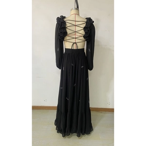 Detail of elegant black chiffon maxi dress featuring backless tie-up design and ruffled shoulders