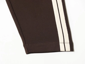 Detail view of dark brown knitted fabric with white side stripes and clean stitching