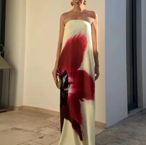 Close-up of silky satin fabric with red and black floral prints on a long tube dress